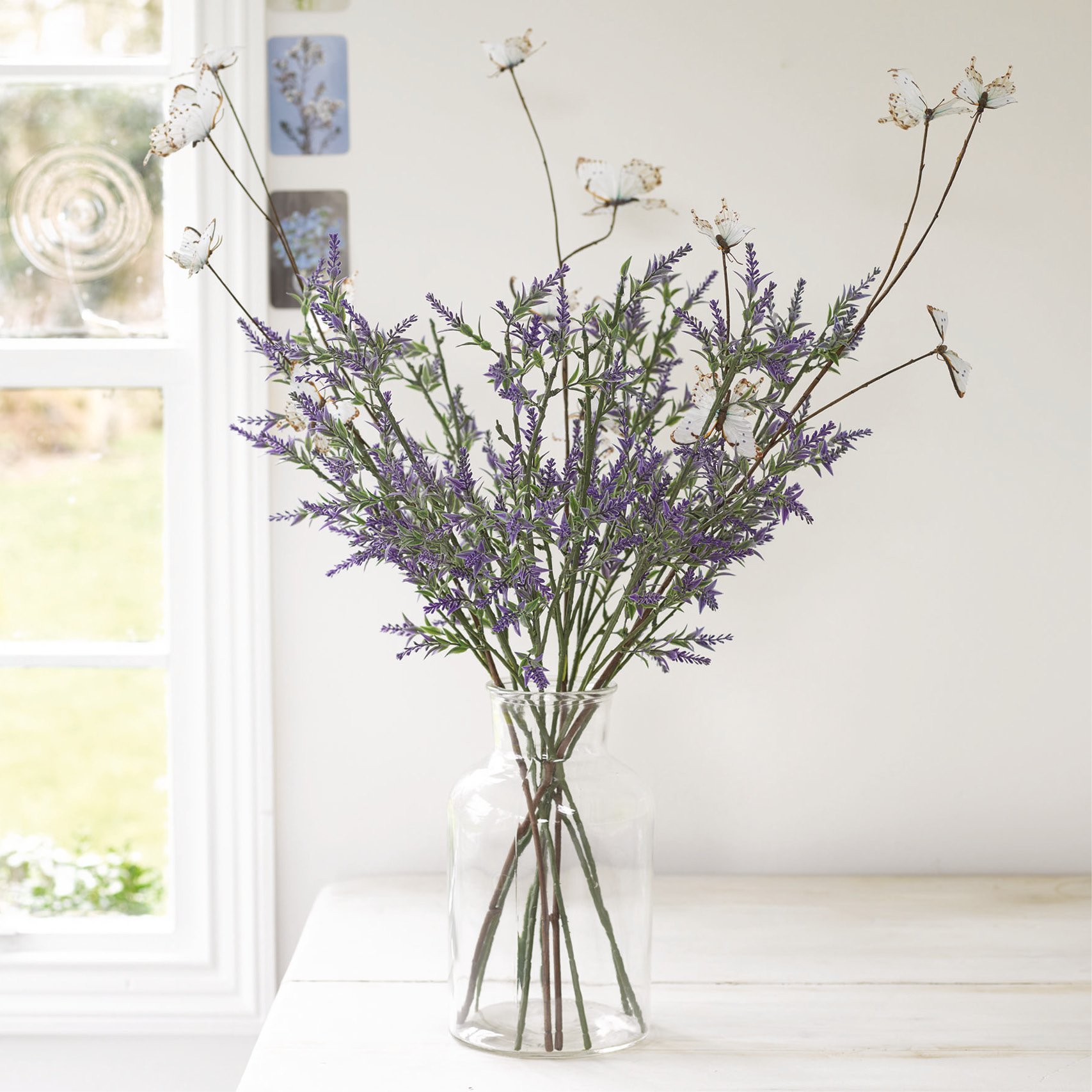Faux purple lavender stems in glass vase