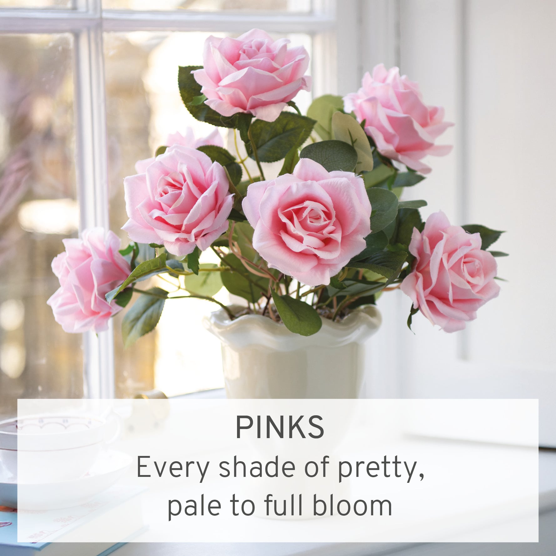 Faux pink roses arranged in white vase