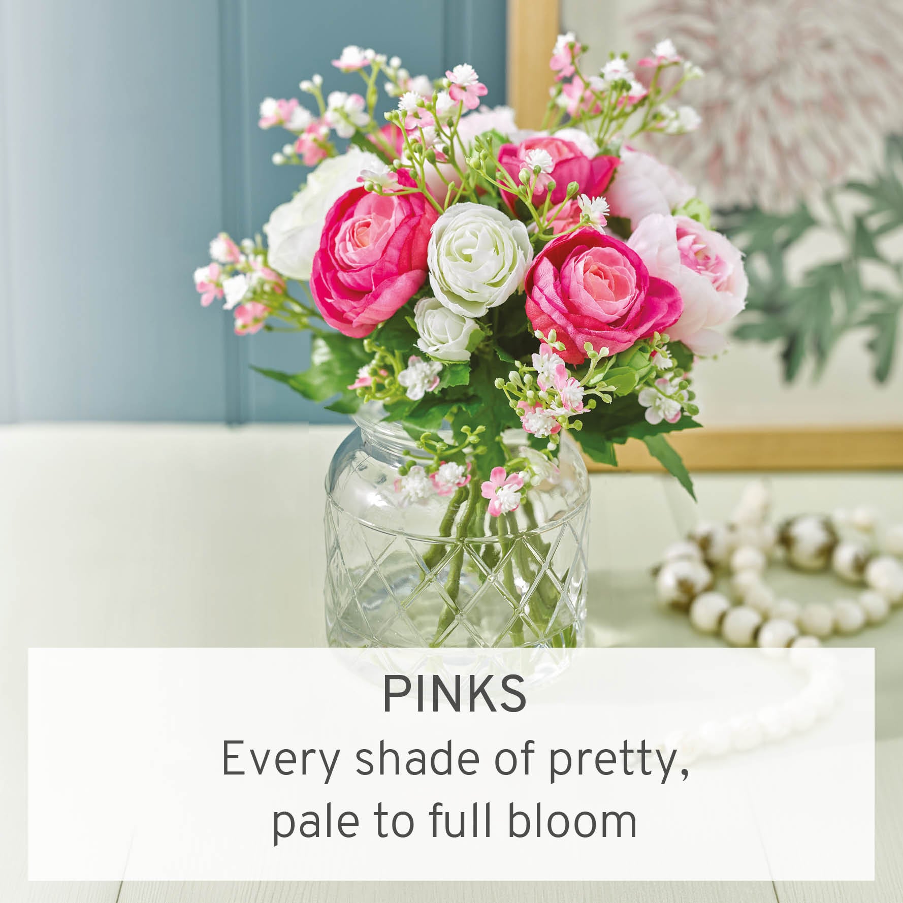 Faux pink flowers in glass vase