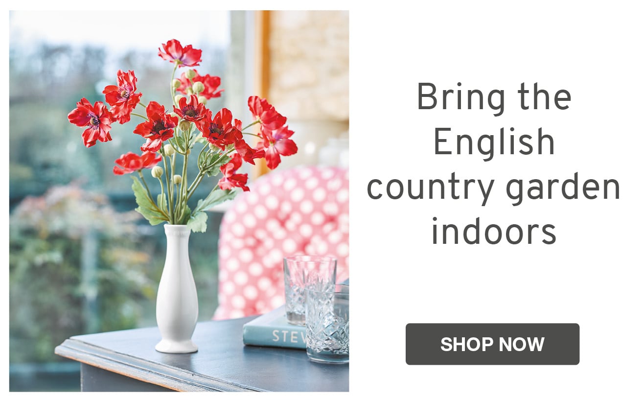 Faux red poppies in slim white vase