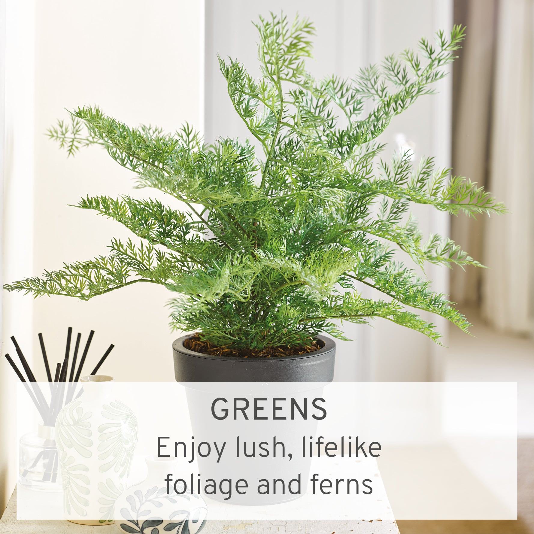Faux green fern in black vase