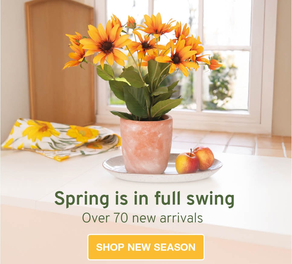 Faux floral arrangement with orange flowers and terracotta vase