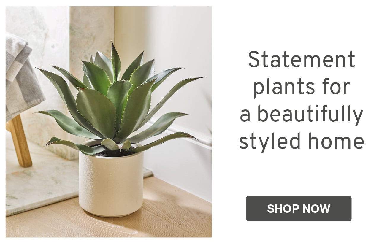 Faux green plant in white planter