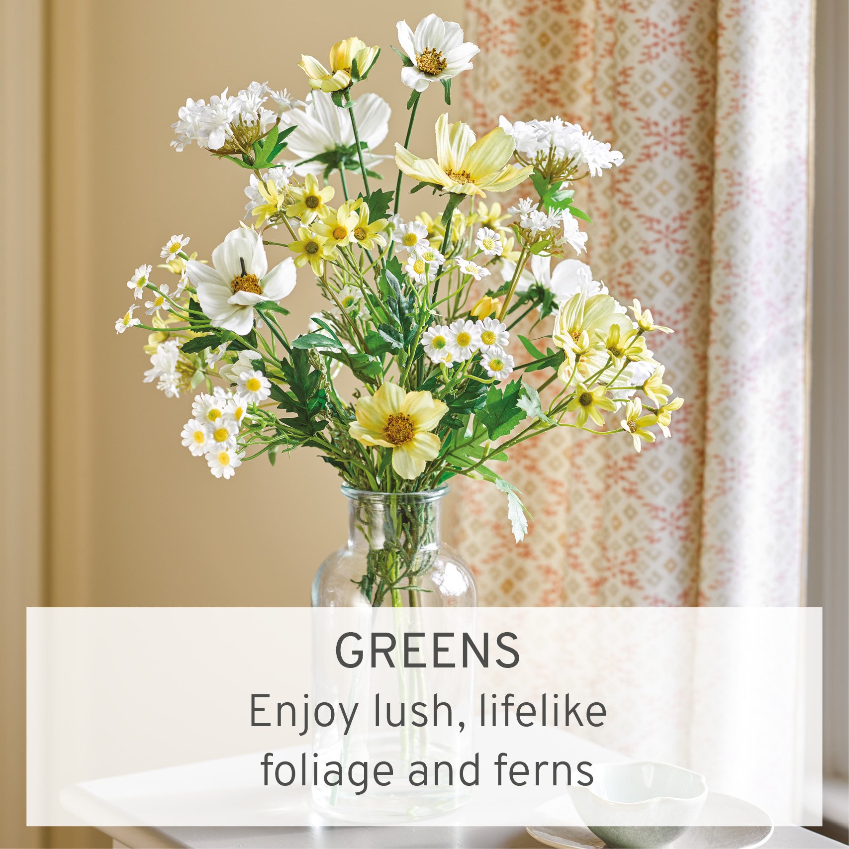 Faux cosmos and daisies in glass bottle vase
