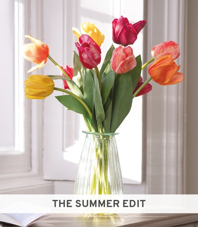 Faux brightly coloured tulips on a windowsill